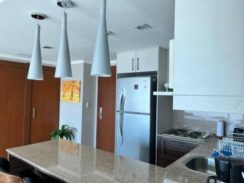 a kitchen with white cabinets and a refrigerator at River View Suites Guayaquil in Guayaquil