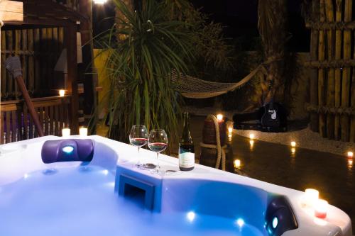 a bath tub with two glasses of wine and candles at Hôtel Cap Pirate in Cap d'Agde