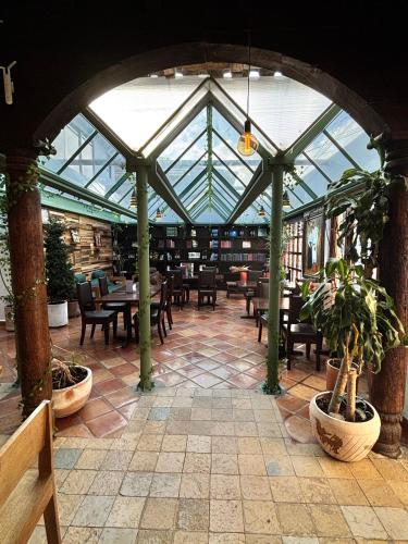 a conservatory with tables and chairs in a library at Axkan Arte Hotel in San Cristóbal de Las Casas