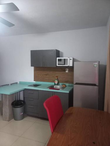 a kitchen with a red chair and a refrigerator at Loft hermoso con estacionamiento gratuito in Monterrey