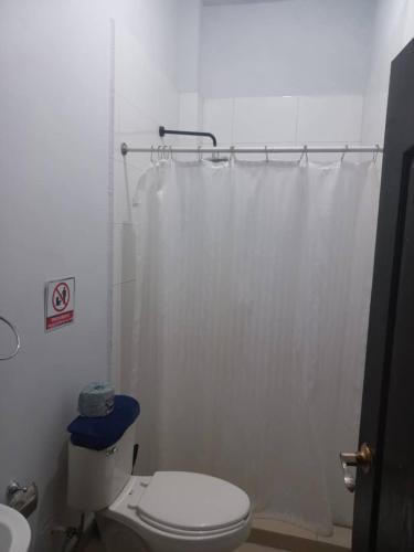 a bathroom with a white shower curtain and a toilet at Loft hermoso con estacionamiento gratuito in Monterrey