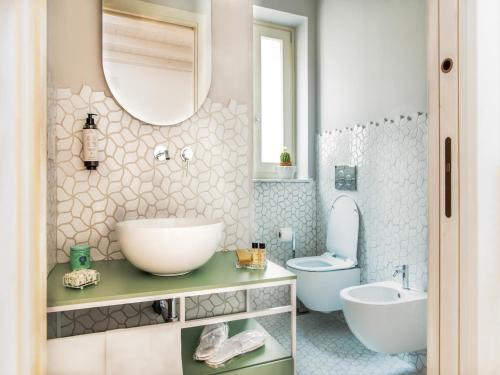 a bathroom with a sink and a toilet and a mirror at Apartment near Mount Etna with Pool in Giarre
