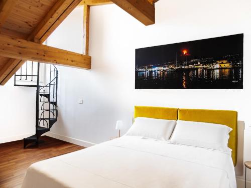 a bedroom with a white bed with a yellow headboard at Apartment near Mount Etna with Pool in Giarre