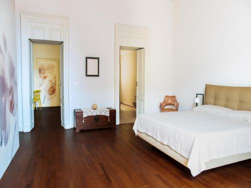 a bedroom with a large white bed and wooden floors at Apartment in Giarre near Mount Etna in Giarre