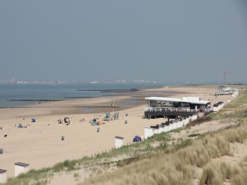 a beach with a pier and people on the sand at Apartment in Groede near the Beach in Groede