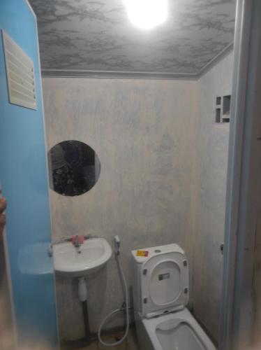 a small bathroom with a toilet and a sink at Air Manis Secret Surfcamp in Taluk Batung