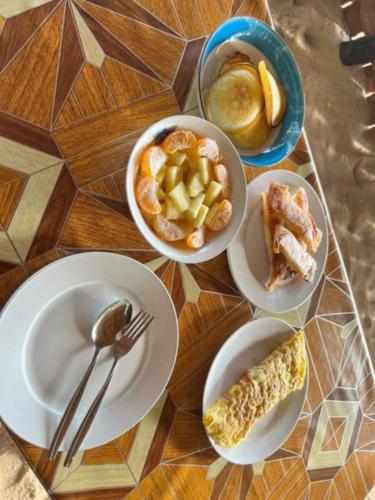 a table with plates and bowls of food on it at DANG dang Balbago Beach in El Nido
