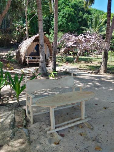 a picnic table and a bench on the beach at DANG dang Balbago Beach in El Nido