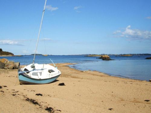 a boat sitting on the sand on a beach at Terraced House in Lanmodez near Sandy Beaches in Lanmodez