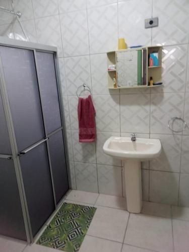 a white bathroom with a sink and a shower at Summer House in Ubatuba in Ubatuba