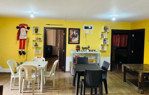 a dining room with yellow walls and a table and chairs at Quinta Los Ángeles in Riobamba