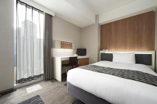 Кровать или кровати в номере Sotetsu Fresa Inn Shimbashi-Karasumoriguchi