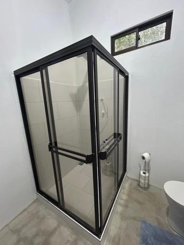a glass shower in a bathroom with a toilet at Bravo paraiso azul beach house in Savegre