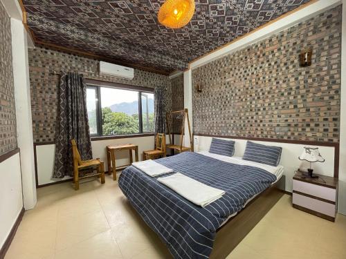 a bedroom with a bed and a brick wall at Mai chau Horizon Homestay in Mai Chau