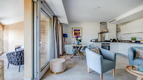 a kitchen and living room with chairs and a table at Fortuna Residence in Saint-Tropez