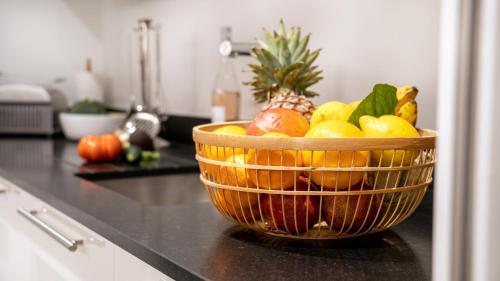 a basket of fruit on a counter in a kitchen at Fortuna Residence in Saint-Tropez