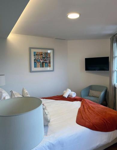 a bedroom with a large bed and a chair at Fortuna Residence in Saint-Tropez