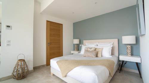 a bedroom with a large white bed with pillows at Fortuna Residence in Saint-Tropez