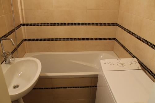 a bathroom with a sink and a white tub and a sink at Louis Apartment in Budapest