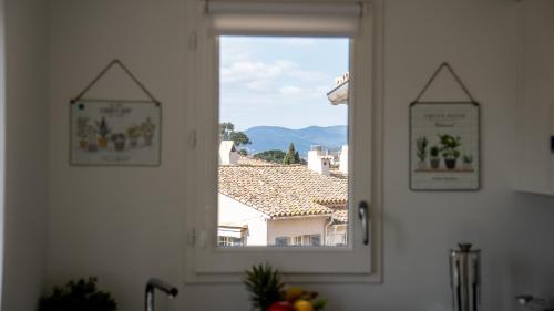 a window in a kitchen with a view of a house at Fortuna Residence in Saint-Tropez