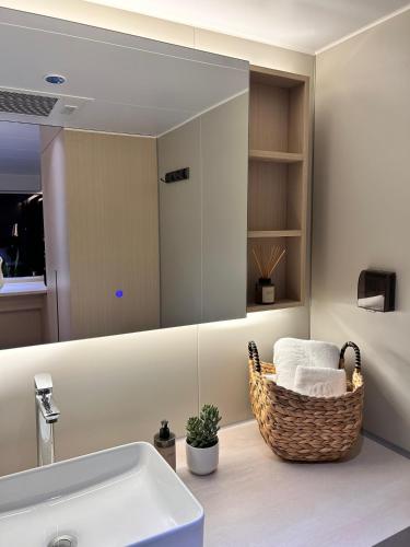 a bathroom with a sink and a basket of towels at Dionisio by LOEW Valle de Guadalupe, Ensenada, México in El Porvenir