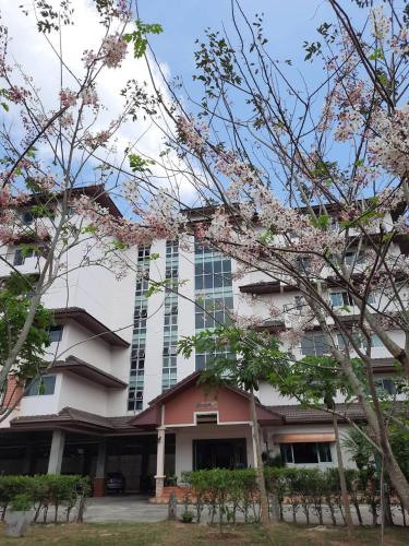 a building with flowering trees in front of it at Ingfah Mountainview in Hat Yai