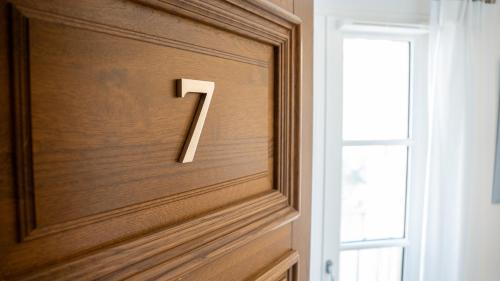 a number on a wooden door with a window at Fortuna Residence in Saint-Tropez