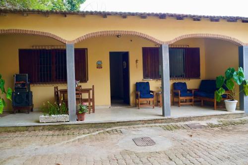 a house with chairs and a table in front of it at Pousada Villa Bella in Maricá