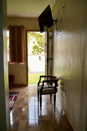 a room with a chair and a door with a window at Pousada Villa Bella in Maricá