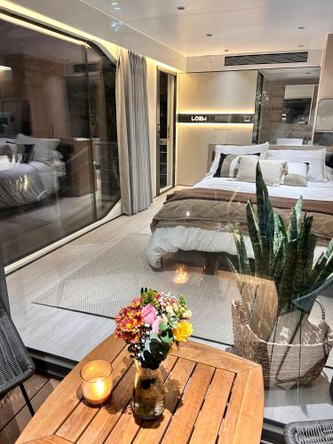 a bedroom with two beds and a table with flowers at Dionisio by LOEW Valle de Guadalupe, Ensenada, México in El Porvenir