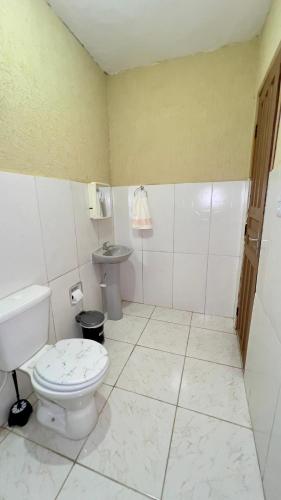 a bathroom with a toilet and a sink at Pousada Villa Bella in Maricá