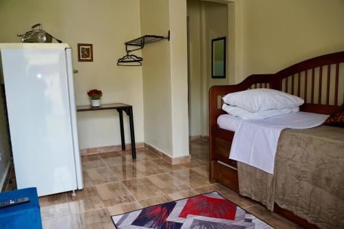 a bedroom with a bed and a table in a room at Pousada Villa Bella in Maricá