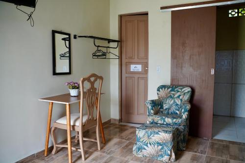 a living room with a chair and a table at Pousada Villa Bella in Maricá