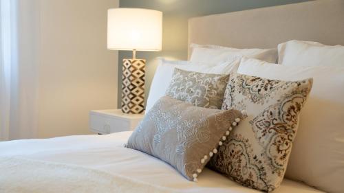 a bedroom with a bed with pillows and a lamp at Fortuna Residence in Saint-Tropez