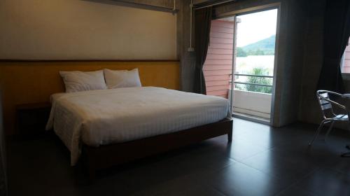 a bedroom with a bed and a window with a view at Ingfah Mountainview in Hat Yai