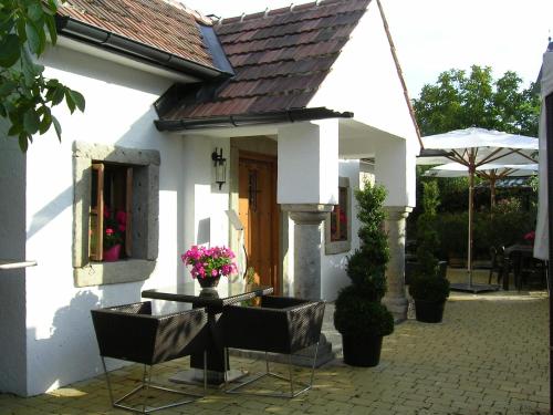 una casa bianca con un tavolo e sedie di fronte di Romantik Chalet a Breitenbrunn am Neusiedler See
