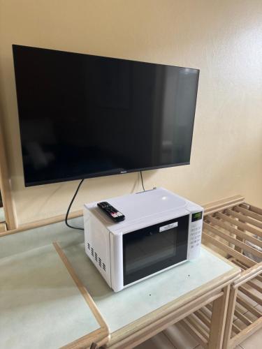 a tv on top of a microwave on a table at Chelsea Motor Inn in Coffs Harbour