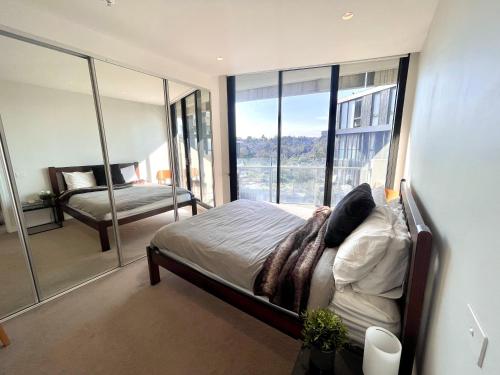 a bedroom with a bed and a large window at Riverside Retreat in Melbourne