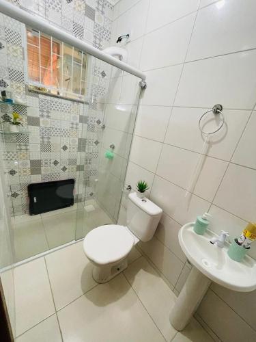 a bathroom with a toilet and a shower and a sink at Residência in São José
