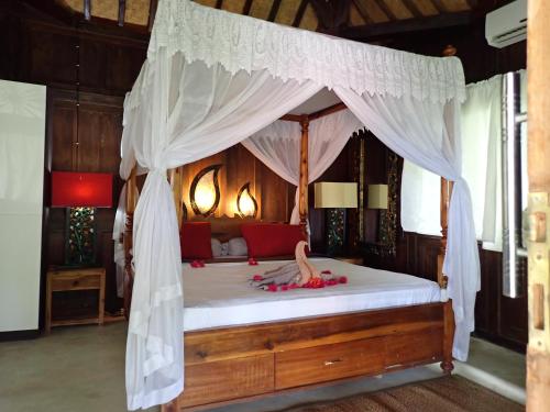 une chambre avec un lit à baldaquin dans l'établissement Amed Homestay, à Amed