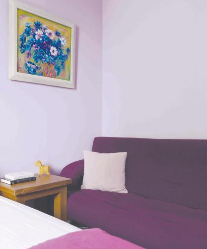 a bedroom with a purple couch next to a table at REST Book & Bed in Puli