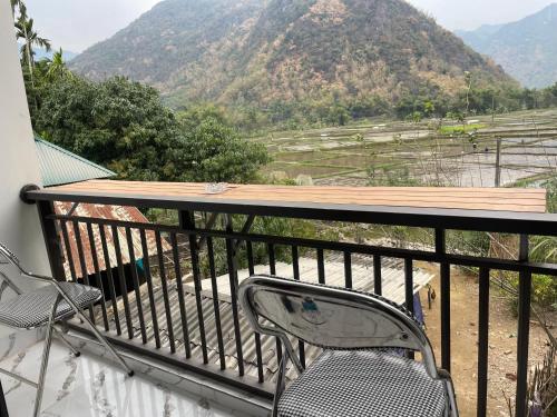 a table and chair on a balcony with a view of mountains at Mai chau Horizon Homestay in Mai Chau