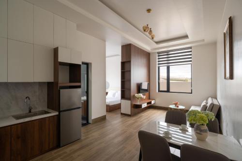 a kitchen and living room with a table and chairs at Anteaus Hotel Đà Lạt in Da Thien