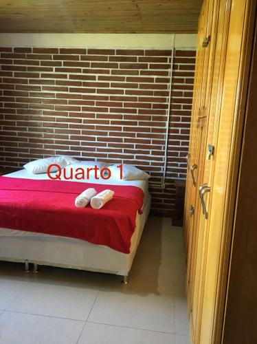 a room with a bed with a red blanket at Pousada e Residencial Linda in Capão da Canoa
