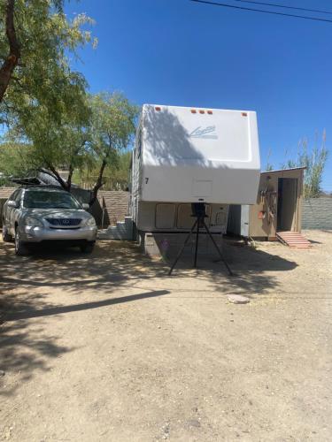 a camper is parked next to a car at Super Saver 5th wheel #7 in Tucson