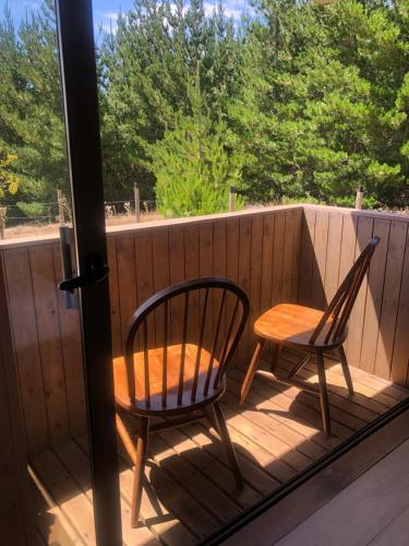 two chairs and a table on a deck with a window at Alojamiento y Desayuno Privado De lujo C1 in Bucalemu