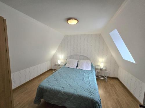 - une chambre avec un lit bleu et 2 tables de nuit dans l'établissement Maison à Aubas: 2 chambres, animaux admis, parking - FR-1-616-185, à Aubas