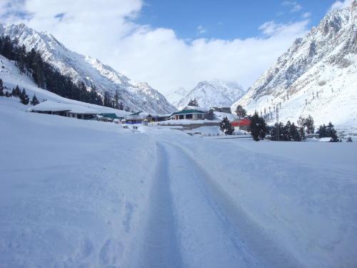 a road covered in snow with mountains in the background at Gilgit Serena Hotel in Gilgit