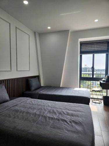 a bedroom with two beds and a window with a view at Eco BMT LUXURY HOTEL in Buon Ma Thuot