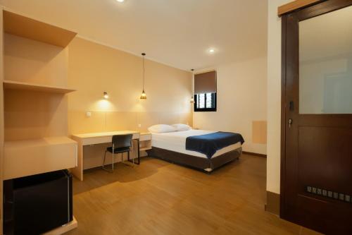 a hotel room with a bed and a desk at Blok M Residence in Jakarta